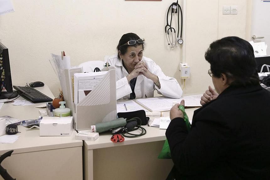 A doctor listening to a patient inside a medical centre of the Greek delegation of the Doctors of the World in Perama, near Athens, on March 5, 2015. -- PHOTO: RETUERS&nbsp;