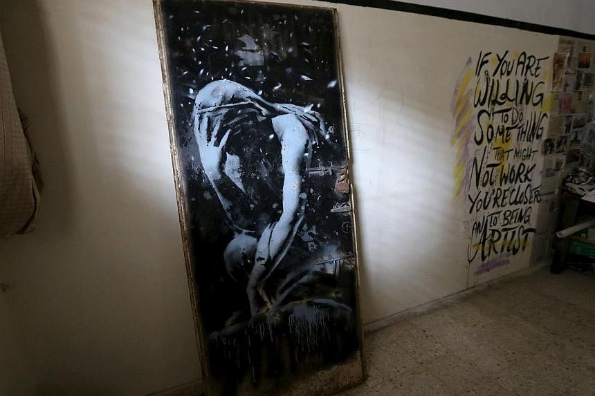 The doorway of a destroyed house, which was painted by British street artist Banksy, is seen inside the gallery of a local Palestinian artist after he bought it from the house's owner, in Khan Younis in the southern Gaza Strip on April 1, 2015. -- PH