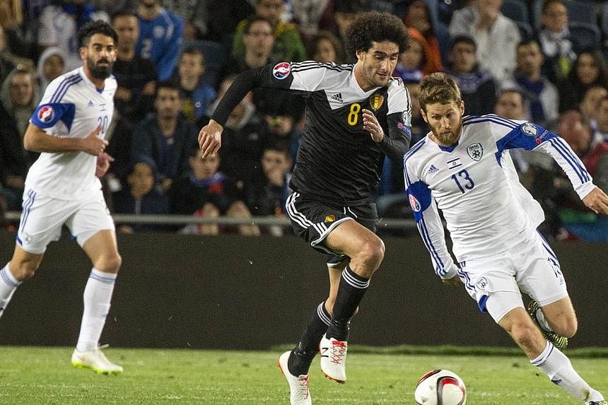 Israel's midfielder Sheran Yeini (right) vying with Belgium's midfielder Marouane Fellaini during their Euro 2016 qualifying football match match between Israel and Belgium on March 31, 2015. -- PHOTO: AFP