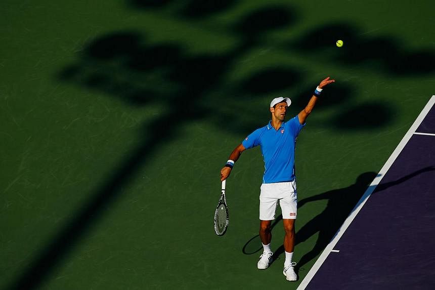 Novak Djokovic serving against Alexandr Dolgopolov during day 9 of the Miami Open at Crandon Park Tennis Center on March 31, 2015, in Key Biscayne, Florida. -- PHOTO: AFP