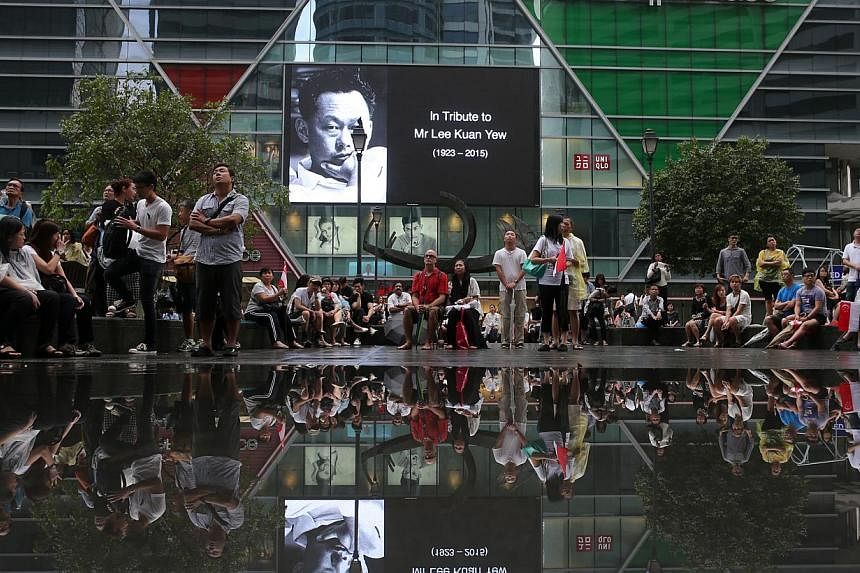 The crowd at Singapore's Raffles Place watching the live telecast of Mr Lee Kuan Yew's funeral service on March 29, 2015. -- PHOTO: ST FILE