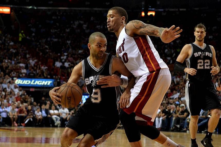 San Antonio Spurs guard Tony Parker (9) dribbles the ball as Miami Heat forward Michael Beasley (30) defends during the second half at American Airlines Arena. The Spurs defeated the Heat 95-81, in a rematch of last season's NBA Finals. -- PHOTO: STE