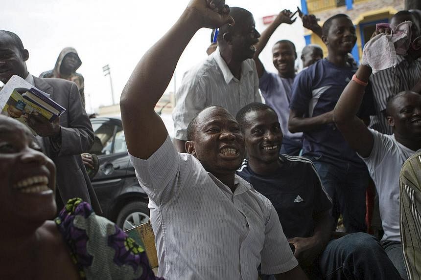 Supporters of presidential candidate Muhammadu Buhari cheer as they watch news coverage of election results favourable to them on a street in Lagos, March 31, 2015. -- PHOTO: REUTERS