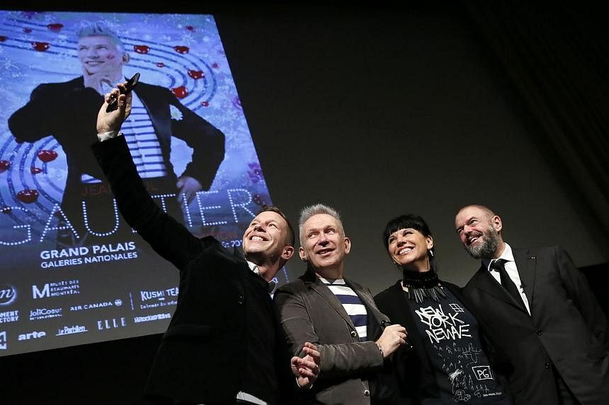 French fashion designer Jean-Paul Gaultier (C), flanked by The Grand Palais Museum president Jean-Paul Cluzel (R), the curator of museum des Beaux arts of Montreal, Nathalie Bondil and the curator of the exhibition Thierry-Maxime Loriot (L), pose for