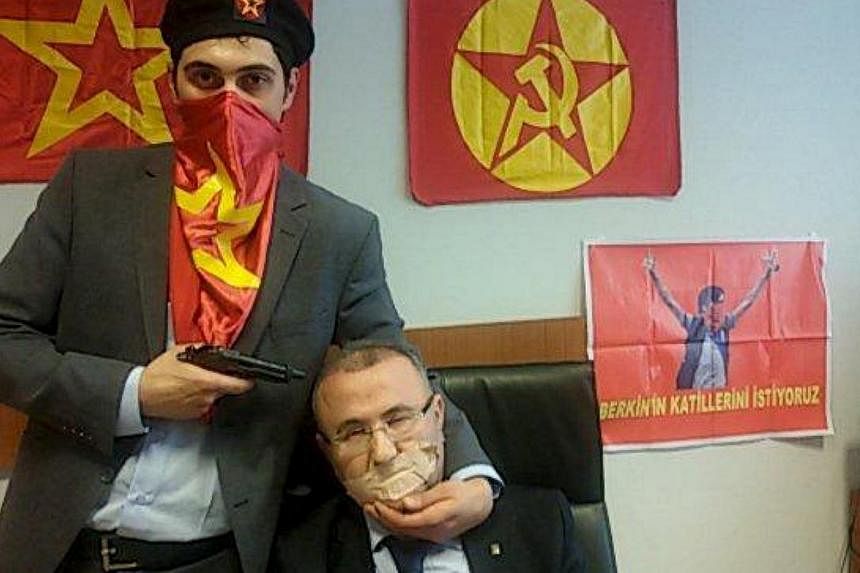 A gunman poses with Prosecutor Mehmet Selim Kiraz with a gun on his head after being taken hostage in his office in a court house in Istanbul March 31, 2015. A senior Turkish prosecutor and his two hostage-takers were killed on Tuesday when security 