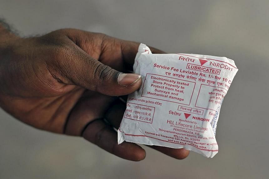 A man shows a packet of government-supplied 'Nirodh' condoms after collecting it from a distribution centre at a hospital in New Delhi on April 1, 2015. -- PHOTO: REUTERS