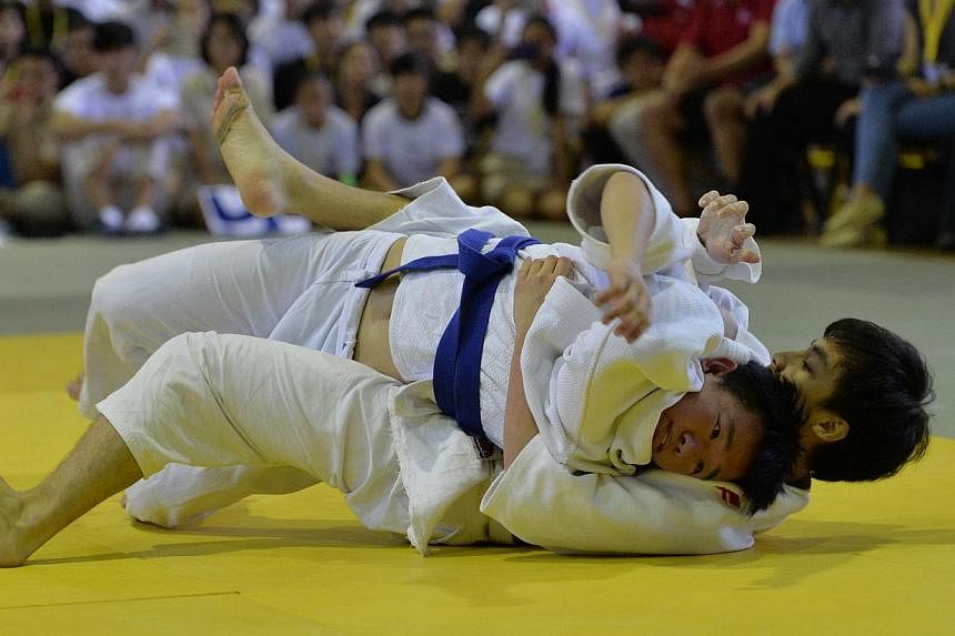 Wesley Kam (with blue belt) from Nanyang Junior College competing with Ong Jia Xiang from Raffles Institution, in the 'A' Division National Team Judo Championship Finals. -- ST PHOTO: CAROLINE CHIA