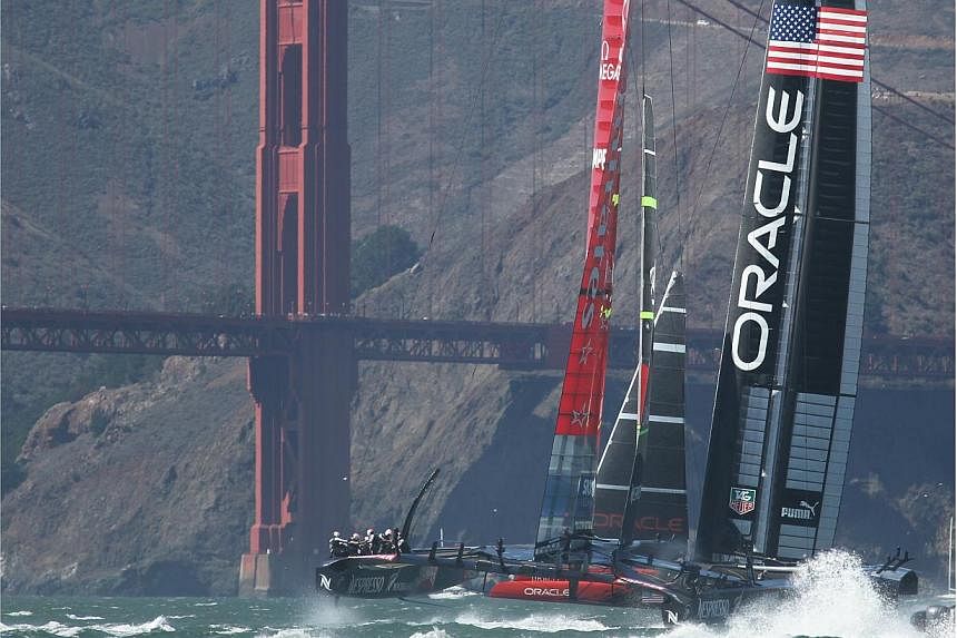 Oracle Team USA and Emirates Team New Zealand racing by the Golden Gate Bridge in the 19th race of the America's Cup on Sept 25, 2013.&nbsp;America's Cup teams have voted to use smaller boats in the historic contest to save money, even though the dec