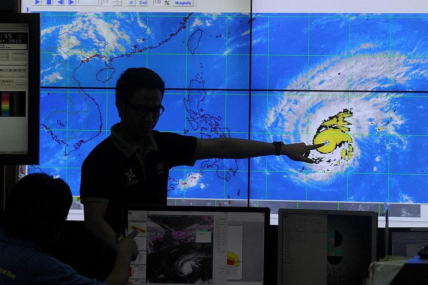 Meteorologists from the Philippine Atmospheric, Geophysical and Astronomical Services Administration (PAGASA) monitor and plot the direction of super typhoon Maysak at PAGASA headquarters in suburban Manila on April 1, 2015. -- PHOTO: AFP