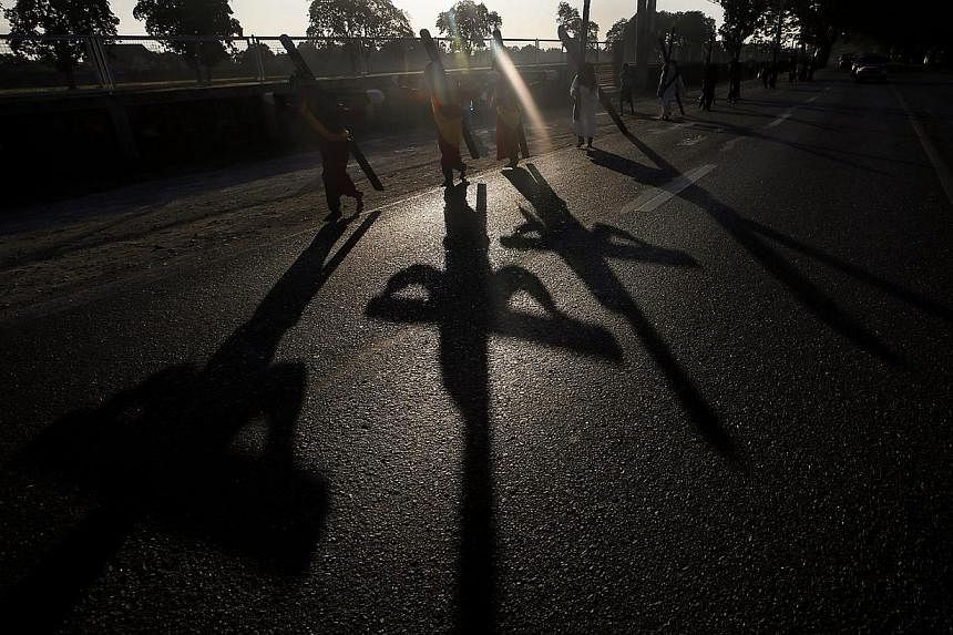 Filipino flagellants carry a wooden cross on their back along a street on Maundy in Mabalacat city, Pampanga Province, in Philippines on April 2, 2015. -- PHOTO: EPA