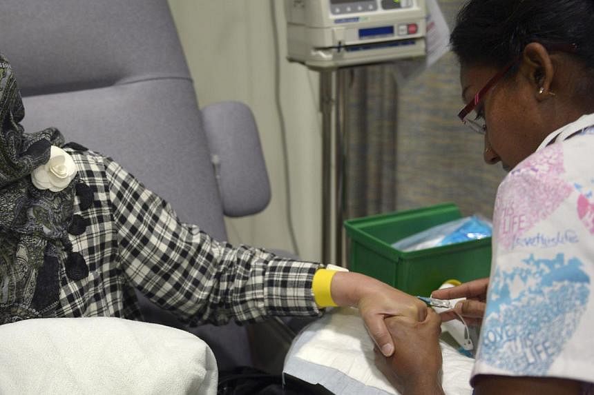 A nurse inserting a needle into a patient's hand for chemotherapy treatment at the National Cancer Centre Singapore (NCCS). A study by the Lien&nbsp;Centre for Palliative Care and collaborators from NCCS has found that late-stage cancer patients woul