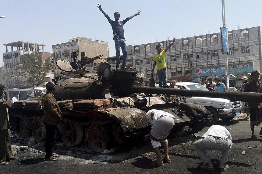 Boys stand on a tank burned during clashes on a street in Yemen's southern port city of Aden March 29, 2015.&nbsp;Rebel forces seized Yemeni President Abedrabbo Mansour Hadi's palace in his former southern refuge of Aden on Thursday, April 2, a senio