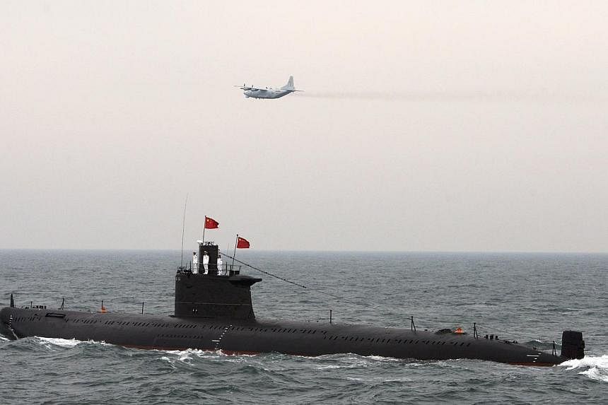 A military aircraft flies past a Chinese Navy submarine at an international fleet review to celebrate the 60th anniversary of the founding of the People's Liberation Army Navy in Qingdao, Shandong province, on April 23, 2009.&nbsp;Pakistani Prime Min