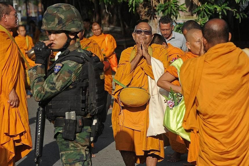A Thai soldier provides security as Buddhist monks collect alms to mark Princess Maha Chakri Sirindhorn's birthday in Narathiwat, southern Thailand on April 2, 2015.&nbsp;A sweeping new security measure in Thailand that has replaced martial law does 
