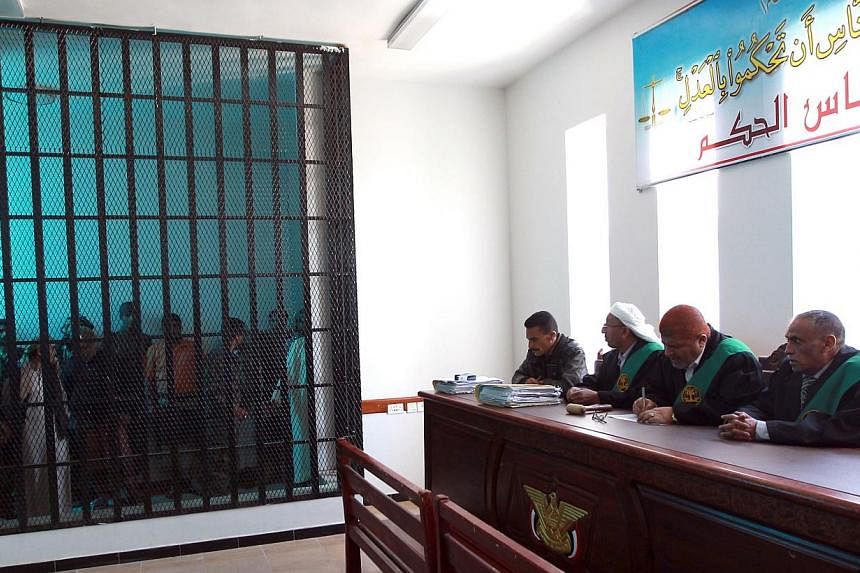 Suspected Al-Qaeda militants stand behind bars during a hearing at the appeals court in the Yemeni capital Sanaa on Feb 10, 2015.&nbsp;Al-Qaeda militants stormed a prison in south-eastern Yemen on Thursday, freeing several hundred inmates including o