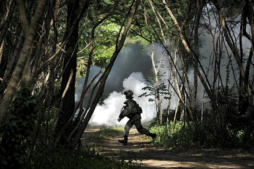 A soldier runing with his weapon during a Singapore Armed Forces (SAF) Readiness Exercise held at Pulau Sudong in 2011. The SAF will be conducting military exercises in several areas islandwide from 8am on April 6 to 8am on April 13. -- PHOTO: ST FIL
