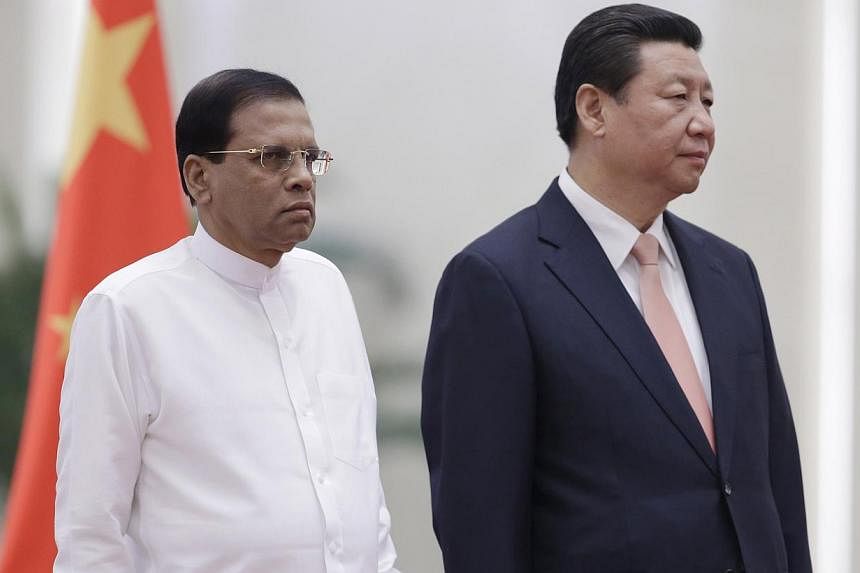 Sri Lanka's President Maithripala Sirisena (left) and China's President Xi Jinping listen to their national anthems during a welcoming ceremony at the Great Hall of the People in Beijing, March 26, 2015. China has pledged over US$1 billion (S$1.3 bil