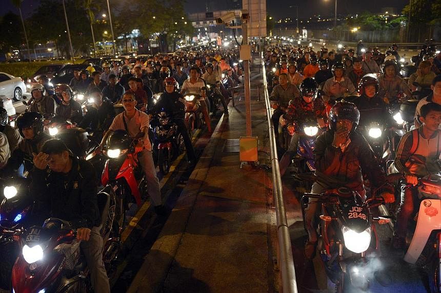 Long queues even at 5.30am as motorcyclists bound for Singapore wait for their turn at the Woodlands checkpoint. Under the tender for the two land checkpoints, at least 110 motorcycles should be cleared per hour per lane when all lanes are in operati