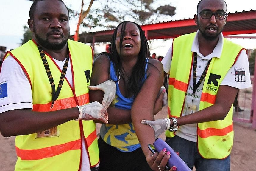 Paramedics help a student who was injured during an attack by Somalia's Al-Qaeda-linked Shebab gunmen on the Moi University campus in Garissa on April 2, 2015.&nbsp;Somali Al-Shabaab militants said they were still holding many hostages inside a Kenya