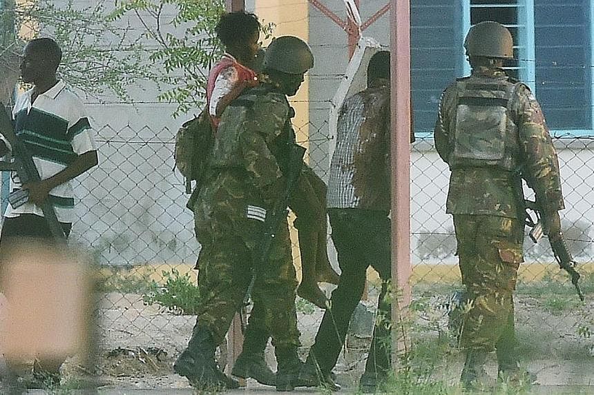 A female student hostage is escorted out of Garissa University after Kenya Defence Forces ended a siege by terrorist gunmen on April 2, 2015.&nbsp;At least 147 students were massacred when Somalia’s Shebab Islamist group attacked a Kenyan universit