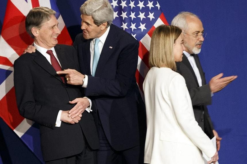 (From left) British Foreign Secretary Philip Hammond, US Secretary of State John Kerry, EU High Representative for Foreign Affairs and Security Policy Federica Mogherini and Iranian Foreign Minister Mohammad Javad Zarif react during a press event aft