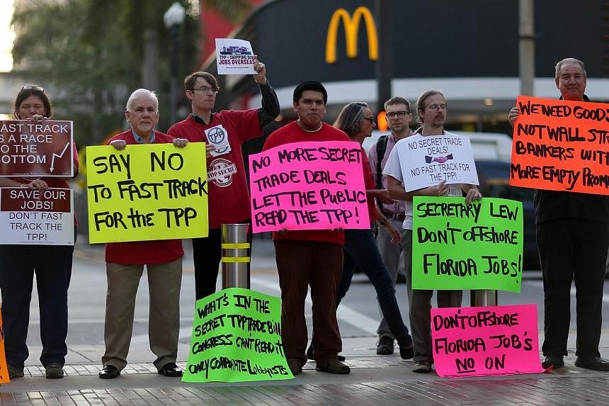 Protesters against the Trans-Pacific Partnership standing outside the Miami Dade College where the Greater Miami Chamber of Commerce was hosting US Treasury Secretary Jacob Lew on March 20, 2015. -- PHOTO: AFP