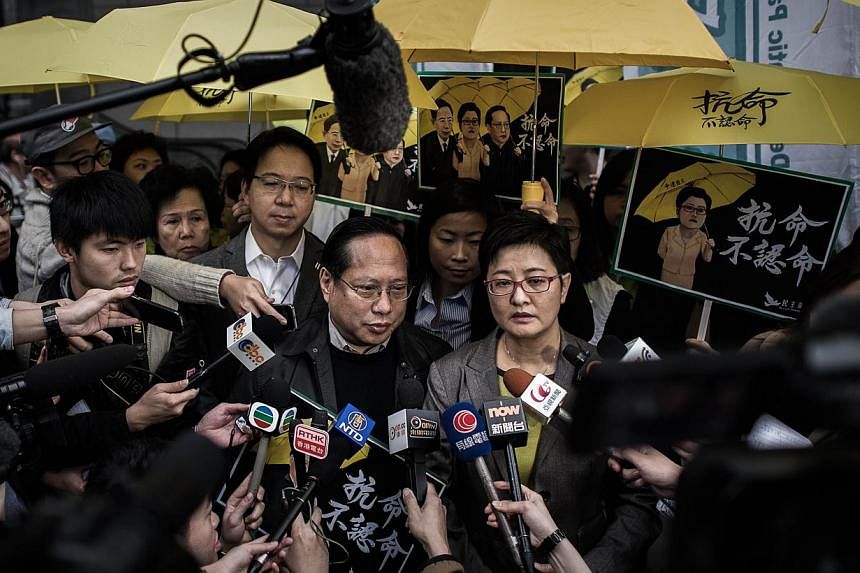 Albert Ho (centre, left) and Helena Wong (centre, right), both of the Democratic Party, speaking to the media outside the Wanchai police station in Hong Kong on March 2, 2015. -- PHOTO: AFP