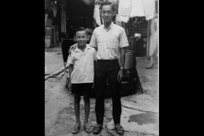 Mr Lim's mother Yeoh Sai Hoo (above, in red) and his late father Lim Ah Tee (in a sports jacket) giving Chinese New Year hongbao to leprosy patients in 2006, at a lunch that they hosted annually. At right, Mr Lim (right) in 1964 with a neighbour in t