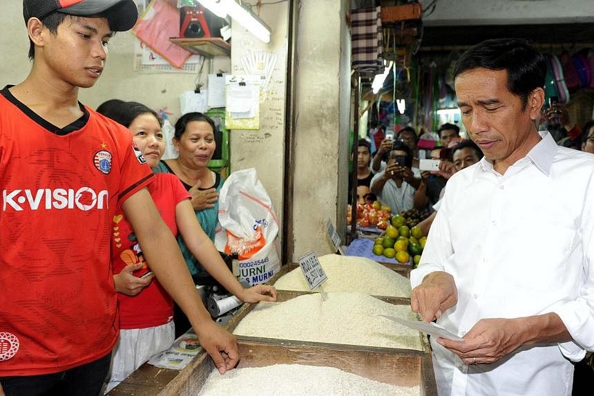 Mr Joko Widodo (right) visiting a traditional food market in Jakarta. With a slowing economy, the Indonesian President needs to attract investments. But to do that, he must address bureaucratic bottlenecks, reform the civil service, broaden the inves