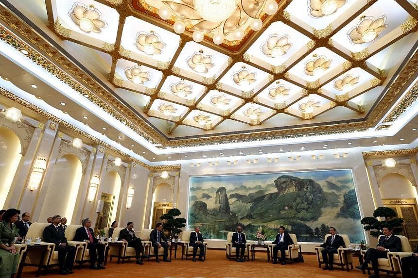 China's President Xi Jinping (fourth from right) meets with the guests at the Asian Infrastructure Investment Bank (AIIB) launch ceremony at the Great Hall of the People in Beijing in this Oct 24, 2014 file photograph. -- PHOTO: REUTERS