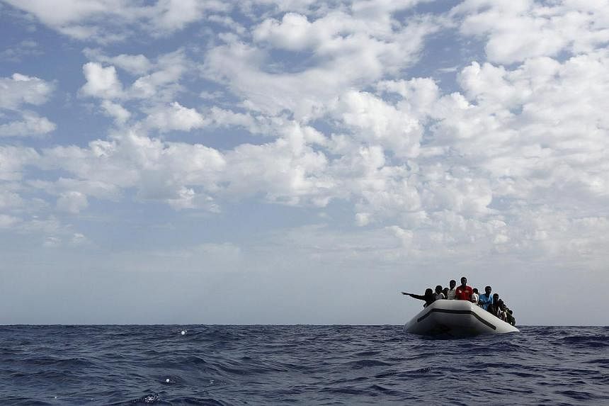 A group of 106 sub-Saharan Africans on board a rubber dinghy wait to be rescued by the NGO Migrant Offshore Aid Station some 25 miles off the Libyan coast, in this Oct 4, 2014 file photo. -- PHOTO: REUTERS
