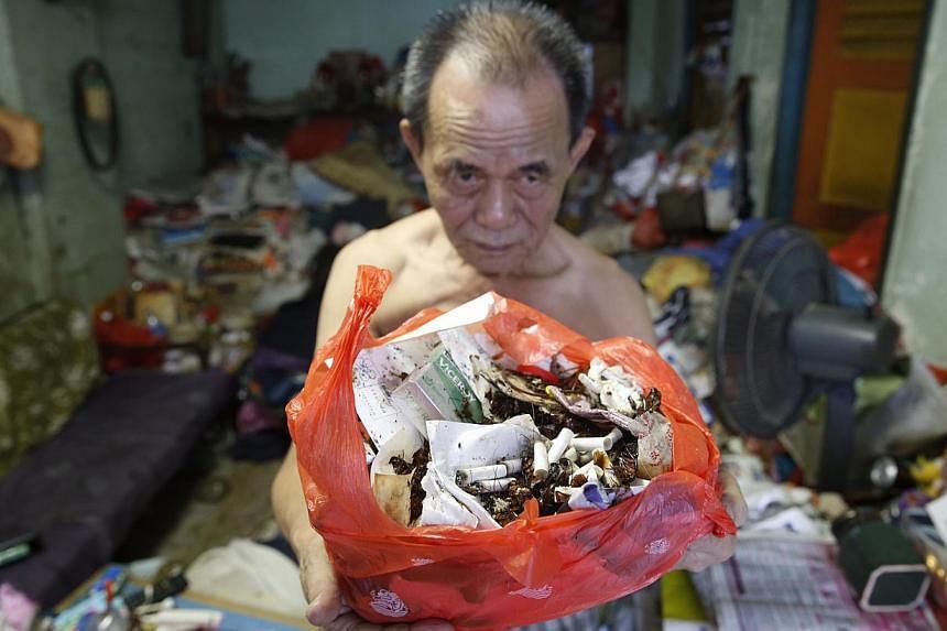 Mr Lim Chin Ting, 74, with a bag of cockroach remains and rubbish from his Eunos Crescent flat. His wife, Madam Soh Siew Zhen, has a compulsive hoarding habit, leading to a cluttered flat overrun by cockroaches and flies.