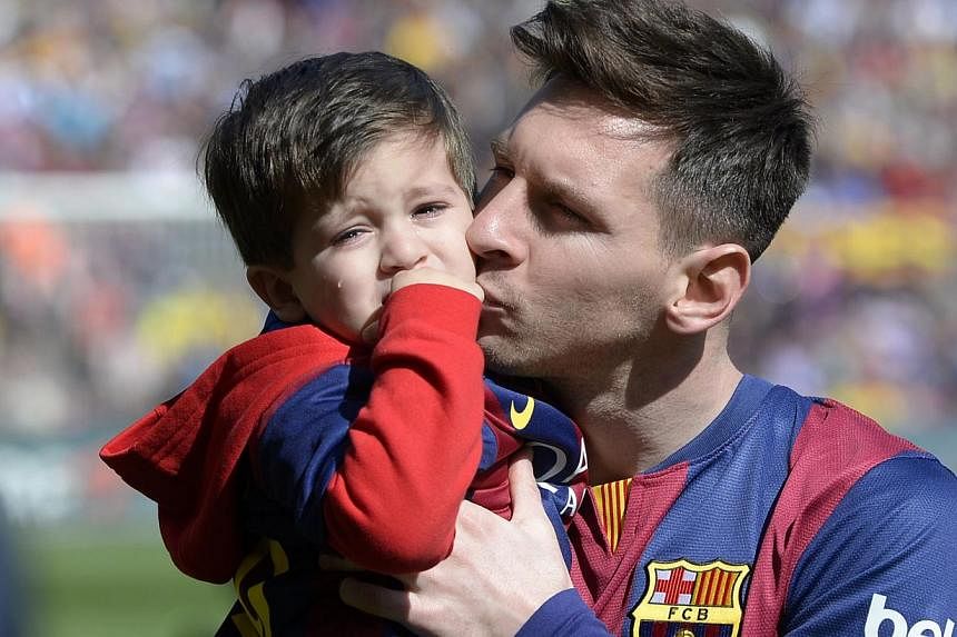 Barcelona's Argentinian forward Lionel Messi holds his son Thiago Messi before playing against Rayo Vallecano on March 8, 2015. Barcelona superstar Lionel Messi announced on Thursday he is to be a father again by posting a picture of his pregnant par