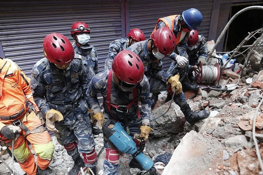 Members of a search and rescue team work in the rubble of a destroyed building in Kathmandu, Nepal, 01 May 2015. One thousand people from the European Union are missing in Nepal and 12 are confirmed dead, nearly a week after a devastating earthquake,