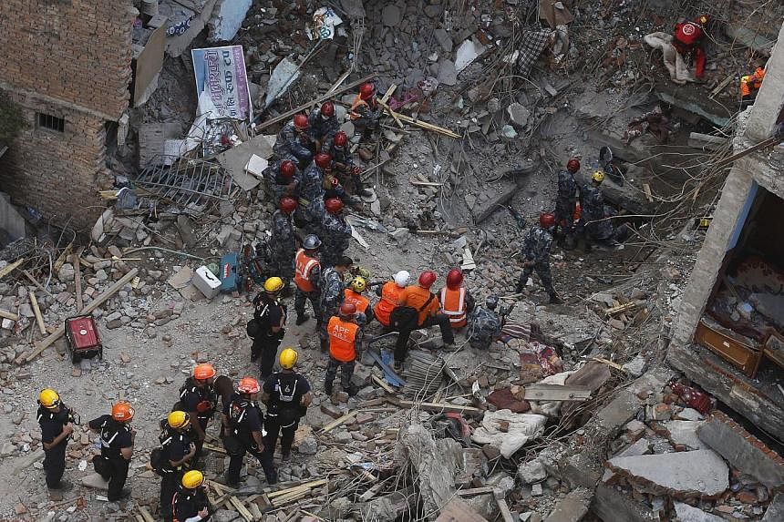 Members of a rescue team from Hungary and Nepal armed police personnel search for earthquake survivors under the debris of a collapsed building, in Kathmandu, Nepal on April 30, 2015. -- PHOTO: REUTERS