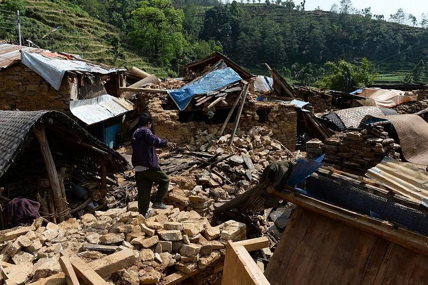 A Nepalese villager walks on the rubble of damaged homes in Baluwa, Gorkha District on May 1, 2015, following a 7.8 magnitude earthquake which struck the Himalayan nation on April 25, 2015. -- PHOTO: AFP