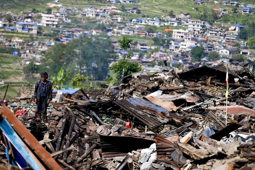 A man standing on what is left of his village as residents return to their dilapidated homes to salvage what they can in Barpak village at the epicentre of the devastating earthquake that hit the country in Nepal on May 1, 2015. -- PHOTO: EPA