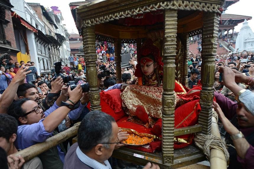 Nepal's Living Goddess the "Kumari Devi" is carried by worshippers during a procession on the third day of the Seto Machindranath chariot festival in Kathmandu on March 29, 2015. --PHOTO: AFP