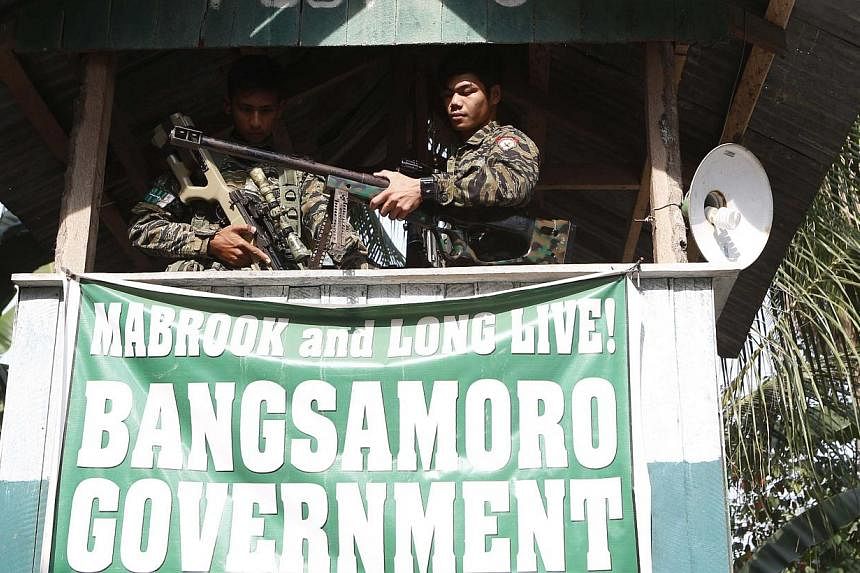 Moro National Liberation Front (MILF) rebels take up position at a guard post at Camp Darapanan rebel base in Maguindanao province, in the southern Philippines, on March 12, 2015. -- PHOTO: REUTERS