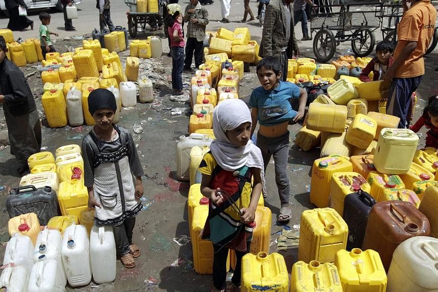 Yemeni children wait to fill their jerrycans with water from a public tap amid an acute shortage of water supply to houses in the capital Sanaa, on April 26, 2015. -- PHOTO: AFP