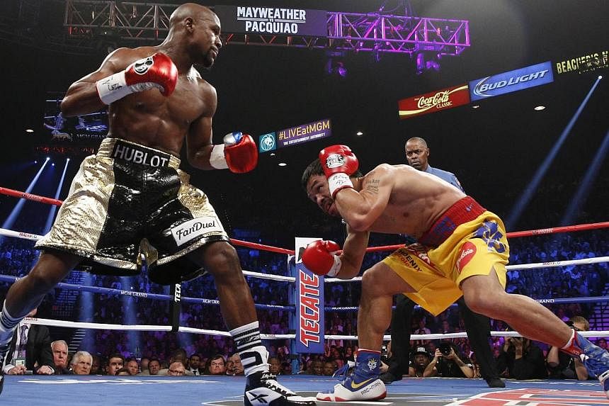 Floyd Mayweather Jr. and Manny Pacquiao (right) fight in a welterweight unification bout on May 2, 2015 at the MGM Grand Garden Arena in Las Vegas, Nevada. -- PHOTO: AFP&nbsp;