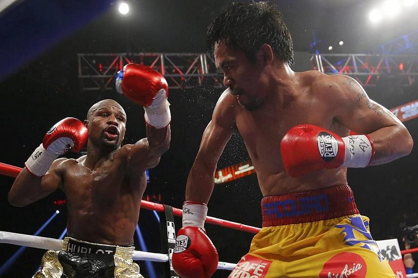 Floyd Mayweather, Jr. of the U.S. (left) and Manny Pacquiao of the Philippines fight in the tenth round during their welterweight WBO, WBC and WBA (Super) title fight in Las Vegas, Nevada, on May 2, 2015. -- PHOTO: REUTERS