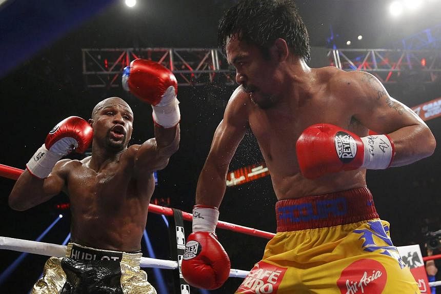 Floyd Mayweather of the US (left) and Manny Pacquiao of the Philippines fight in the tenth round during their welterweight WBO, WBC and WBA (Super) title fight in Las Vegas, Nevada, on May 2, 2015. -- PHOTO: REUTERS