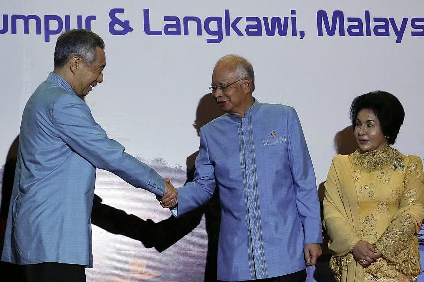 Singapore's Prime Minister Lee Hsien Loong (left) shake hands with Malaysian Prime Minister Najib Razak (centre) during the 26th Asean Summit in Kuala Lumpur on April 26, 2015. -- PHOTO: EPA&nbsp;