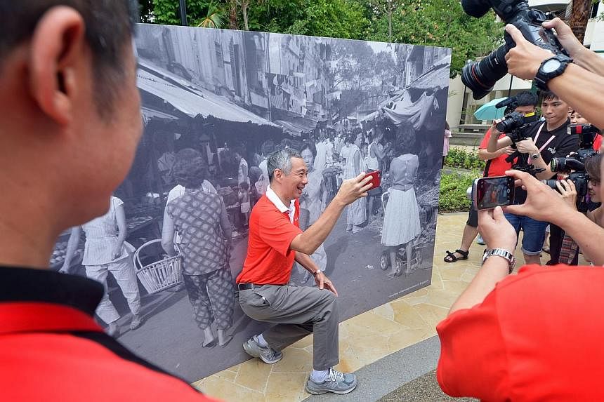 Prime Minister Lee Hsien Loong takes a selfie in front of a mural at the SG50 Carnival by Ang Mo Kio-Hougang Grassroots Organisations at Hougang Avenue 8 on May 3, 2015. -- ST PHOTO: ALPHONSUS CHERN&nbsp;