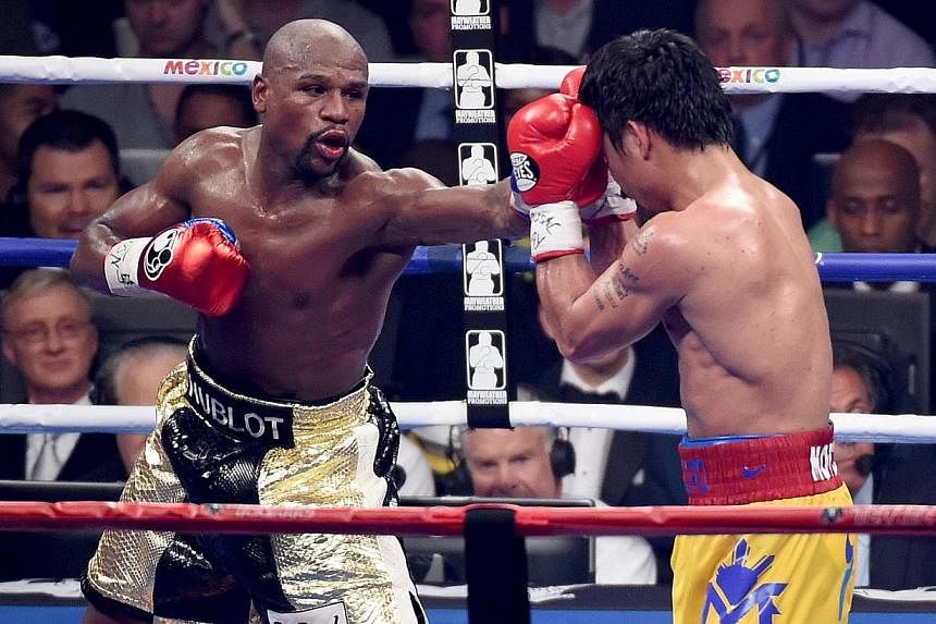 Floyd Mayweather Jr. throws a left at Manny Pacquiao during their welterweight unification championship bout on May 2, 2015 at MGM Grand Garden Arena in Las Vegas, Nevada. -- PHOTO: AFP