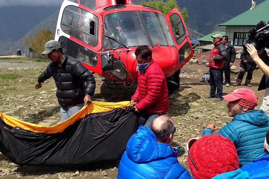 A body bag containing the body of a climber is carried from a helicopter in the Himalayan tourist town of Lukla April 29, 2015.&nbsp;Police have found more than 50 bodies, including those of six foreigners, in Nepal's popular Langtang trekking region