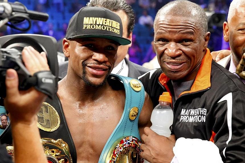 Floyd Mayweather, Jr. of the U.S. and his trainer Rafael Garcia (right) pose for a picture after Mayweather defeated Manny Pacquiao of the Philippines in their welterweight WBO, WBC and WBA (Super) title fight in Las Vegas, Nevada, on May 2, 2015. --