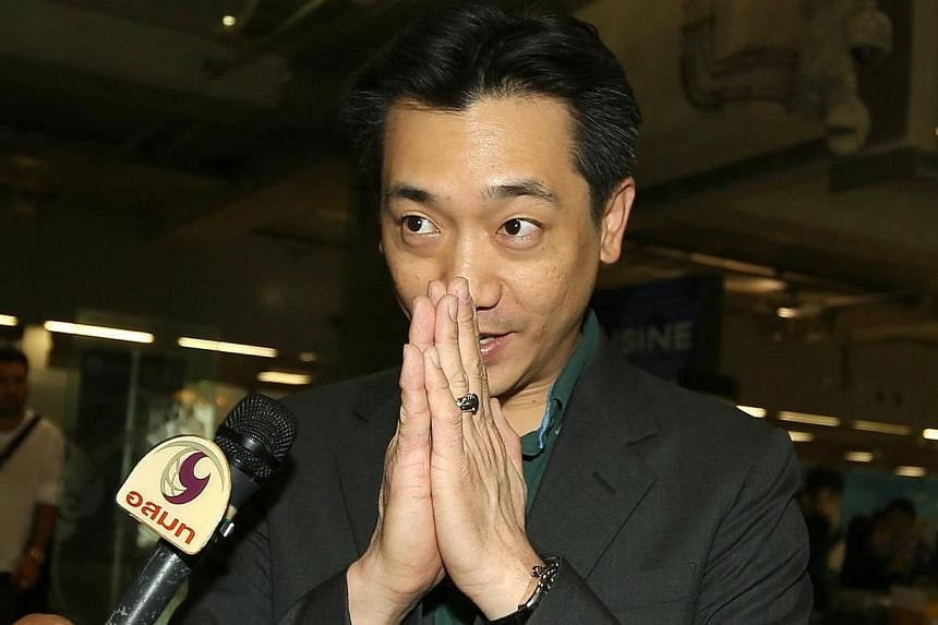 Thai businessman Bee Taechaubol greets the press as he arrives to the Suvarnabhumi airport, after returning from Milan. -- PHOTO: EPA