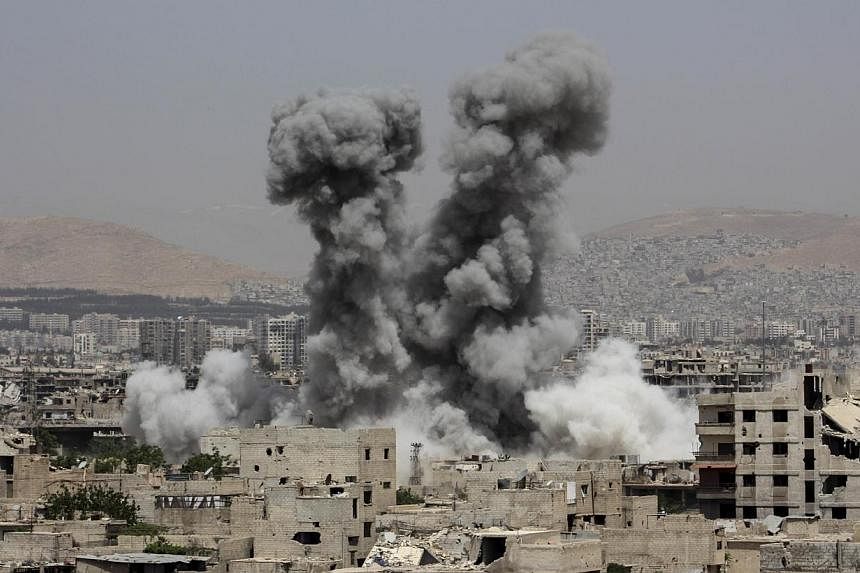 Smoke billows following air strikes by regime forces in the rebel-held area of Ain Tarma, east of the capital Damascus, on April 29, 2015. -- PHOTO: AFP&nbsp;